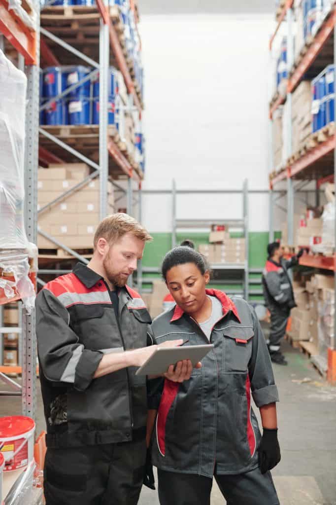 Young foreman showing his mixed-race female colleague list of new goods